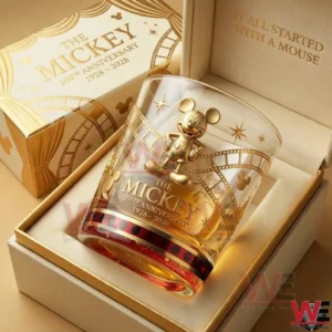 A boxed commemorative whiskey glass with gold Mickey decoration and one hundredth anniversary text from nineteen twenty eight to two thousand twenty eight!