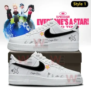 White and black Nike Air Force one sneaker with signature style graphics and star patch shown on a shoebox with a world tour poster background