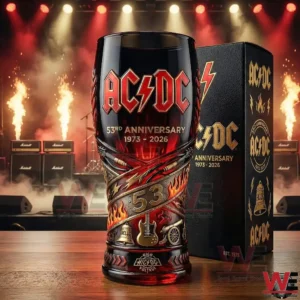 A close up view of an AC DC 53 year anniversary glass placed on a stage themed background with fire effects lighting rigs and rock amplifiers!
