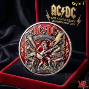 An AC DC anniversary commemorative coin placed inside a red velvet presentation box featuring a guitarist lightning bolts cannons flames and detailed metallic engraving!