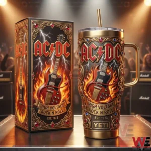 An AC DC themed insulated tumbler and its display box shown on a stage with guitar artwork flames and concert lighting in the background!