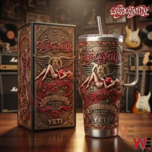 A Yeti tumbler and matching box with elaborate Aerosmith Dream On rock artwork placed on a wooden surface with guitars and records in the background!