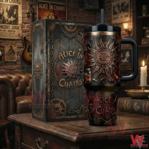 Alice In Chains tumbler with handle and straw next to a matching themed box on a wooden table with rock music decor in the background.
