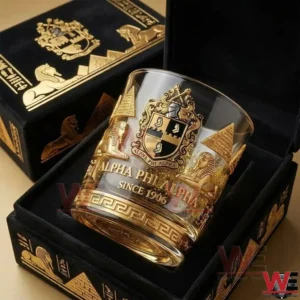 Alpha Phi Alpha whiskey glass placed in a black and gold luxury box featuring an ornate crest and Egyptian themed decorations!