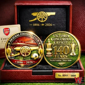 Close up of Arsenal 140 year commemorative coins in a red display case with gold Arsenal cannon emblem 1886 to 2026 and detailed coin faces featuring Arsenal Football Club text trophies and Victoria Concordia Crescit motto