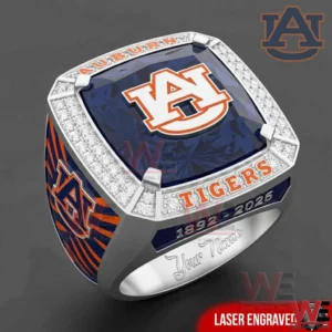 A square top Auburn Tigers commemorative ring with the AU logo on a navy face surrounded by diamond like stones and orange lettering with Auburn themed side details and an engraved interior!