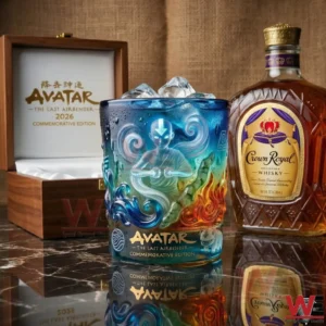 An Avatar inspired glass with ice inside shown in a lifestyle setting with a bottle and wooden box in the background! v