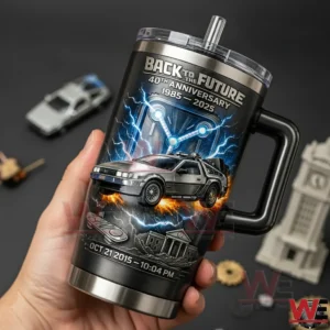 Back to the Future 40th Anniversary 1985-2025 Tumbler 3 Hand holding a black stainless steel handled tumbler with Back to the Future 40th Anniversary 1985 2025 design featuring the DeLorean lightning effects and Oct 21 2015 1004 PM text.