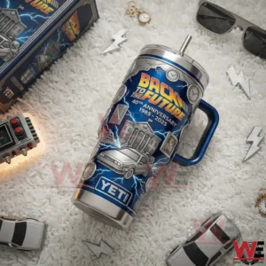 A Back To The Future insulated tumbler placed on a textured surface with toy cars clocks and themed accessories nearby!