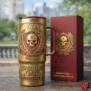 Gold and burgundy Baldurs Gate anniversary tumbler with skull crest next to matching burgundy gift box outdoors.