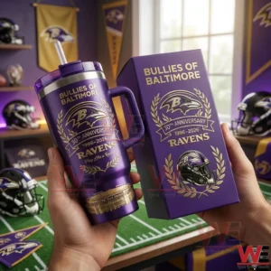 Hands holding a purple Baltimore Ravens tumbler with handle and straw beside a matching 30th anniversary Bullies of Baltimore gift box in a Ravens decorated room