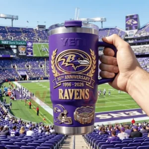 Hand holding a purple YETI Ravens 30th Anniversary tumbler with a football stadium and field in the background!