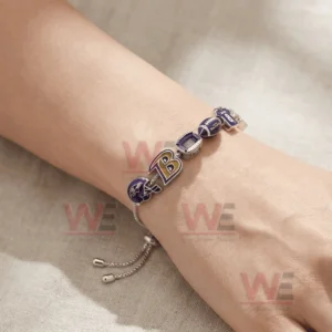 Adjustable charm bracelet on a wrist with Baltimore football themed charms including helmet B logo stadium football jersey number and bird logo!