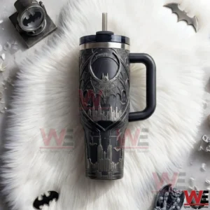 Top view of a dark Batman tumbler with embossed bat emblem Gotham city skyline handle lid and metal straw on a white fur background!