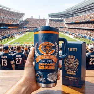 Hand holding a navy Chicago Bears 105th anniversary tumbler with handle and straw in front of a football stadium crowd with a matching commemorative gift box on the table!