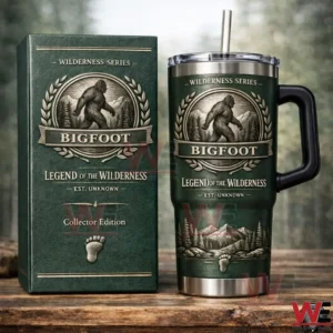Green Bigfoot themed insulated tumbler with handle and straw next to matching Wilderness Series collector edition box on a wooden table!