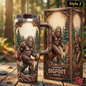Carved wood style Bigfoot insulated tumbler with handle and straw displayed next to a matching box in an outdoor forest background!
