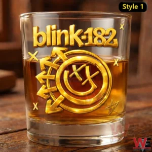 Blink 182 The Rock Show Gold Glass 11 A close up product photo of a blink 182 gold embossed whiskey glass on a rustic wooden table!
