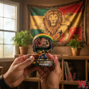 Hands holding a Bob Marley inspired pop style figure with guitar on a decorated base in front of a reggae themed flag with plants and shelves in the background!