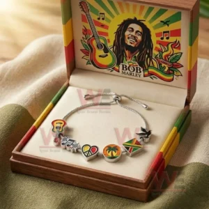 Bob Marley Adjustable Charm Bracelet 3 Open wooden gift box holding a silver adjustable charm bracelet with reggae themed charms and a lid featuring Bob Marley artwork with red yellow and green colors.