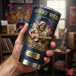 This image shows a person holding a Bobby Weir commemorative tumbler indoors emphasizing the detailed artwork textured surface and music themed environment surrounding the object!