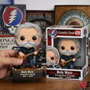 Grey haired bearded guitar player vinyl figure on a small stage base next to a Grateful Dead 470 box with music posters behind!
