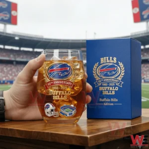Hand holding a Buffalo Bills sixty five year anniversary whiskey glass with ice next to a blue presentation box inside a football stadium!