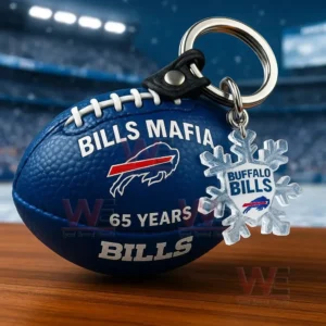 Blue football keychain with Bills Mafia design and Buffalo Bills snowflake charm on a table with a snowy stadium background.