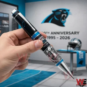 Carolina Panthers 30th Anniversary Keep Punding Pen 3 Hand holding a Carolina Panthers commemorative pen with team logo anniversary display and football helmet in the background in a modern themed room!
