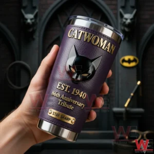 A close view of a Catwoman themed tumbler held in a hand with a dark Gotham background purple leather finish gold cat mask emblem and dramatic lighting!