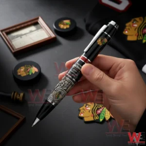 Hand holding a Chicago Blackhawks commemorative pen with team themed items displayed on a dark surface!