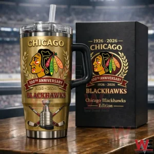 A metallic gold tumbler with hockey symbols and a sturdy handle is displayed next to a premium box on a table in front of an arena scene!