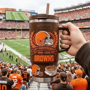 Hand holding a brown YETI Browns 80th Anniversary tumbler with a football stadium and field in the background!