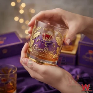 Hand holding a Crown Royal whisky glass with golden drink inside!