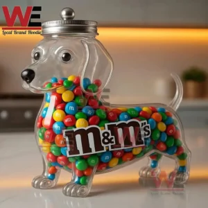Clear dachshund candy jar full of colorful chocolate candies on a kitchen counter with warm lighting.