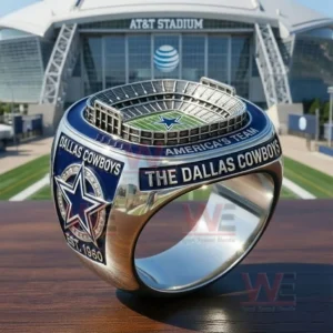 Close up of a Dallas Cowboys ring with a miniature stadium top blue and silver team graphics and Americas Team text displayed in front of AT T Stadium!