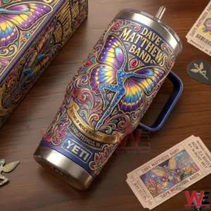 A detailed top angle view of a Yeti tumbler with Dave Matthews Band butterfly artwork styled with concert tickets and music accessories!