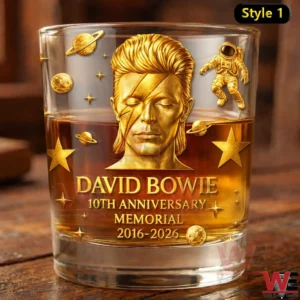 A close view shows a whiskey glass with rich amber drink and a gold David Bowie anniversary memorial surrounded by cosmic motifs!