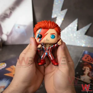 Red haired David Bowie Ziggy Stardust vinyl figure holding a microphone and pointing up with a glittery lightning bolt backdrop!