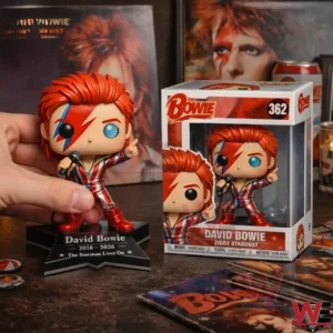 Hand holding a David Bowie Ziggy Stardust vinyl figure next to a Bowie display box with music memorabilia on the tabletop!