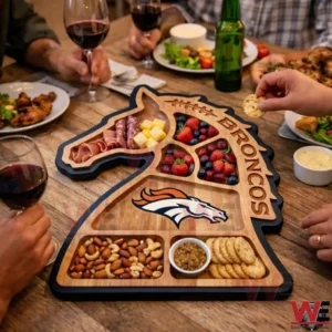 A Denver Broncos wooden charcuterie board filled with food on a table surrounded by people!