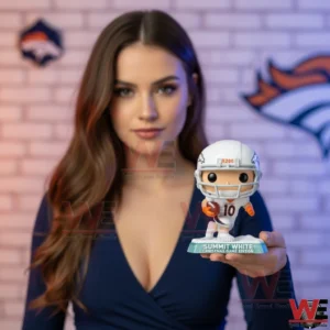 A woman stands indoors holding a Denver Broncos summit white Christmas game edition football figure in her hand!