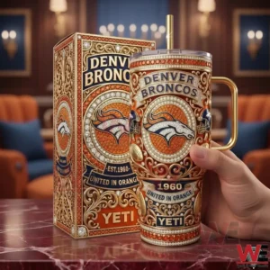Handheld view of an orange and gold insulated tumbler featuring an ornate Denver Broncos design with a metallic handle!