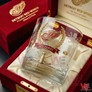 A close up view of a Detroit Red Wings centennial whiskey glass displayed inside a red wooden gift box with soft interior lining and detailed gold anniversary artwork!