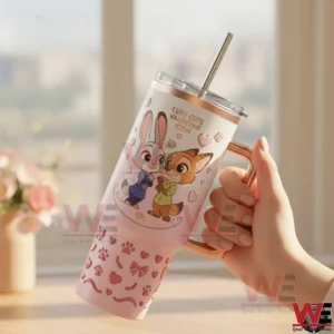 Hand holding a pink insulated tumbler with cute animal illustration hearts and a smooth handle in a bright room!