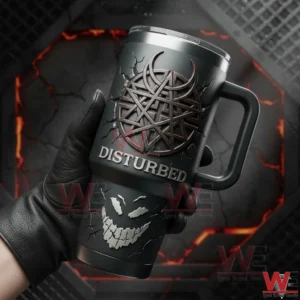 Gloved hand holding a Disturbed insulated tumbler with handle metallic emblem cracked smiling face graphic and bold Disturbed text with a dramatic lava themed background!