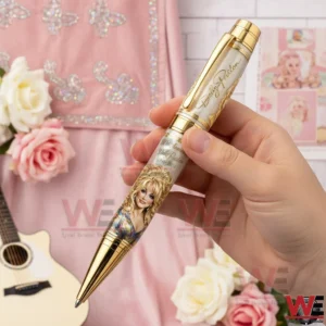 Hand holding a Dolly Parton commemorative pen with portrait artwork and anniversary text against a pink country themed background with roses and a guitar!