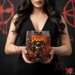A close view of hands presenting a Doom collector whiskey glass with orange logo and detailed character artwork in a dark studio setting!