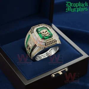 Gold and silver championship ring with a green gemstone face shown inside a blue ring box featuring a skull in a green cap shamrock accents and Dropkick Murphys branding.
