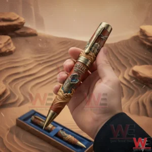 DUNE 60th Annviersary Pen 3 Hand holding a Dune themed anniversary pen with sandworm artwork set against a desert inspired background!